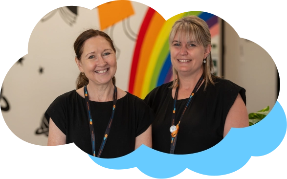Two smiling team members with lanyards around their necks.