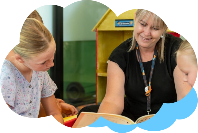 Smiling woman reading to children.